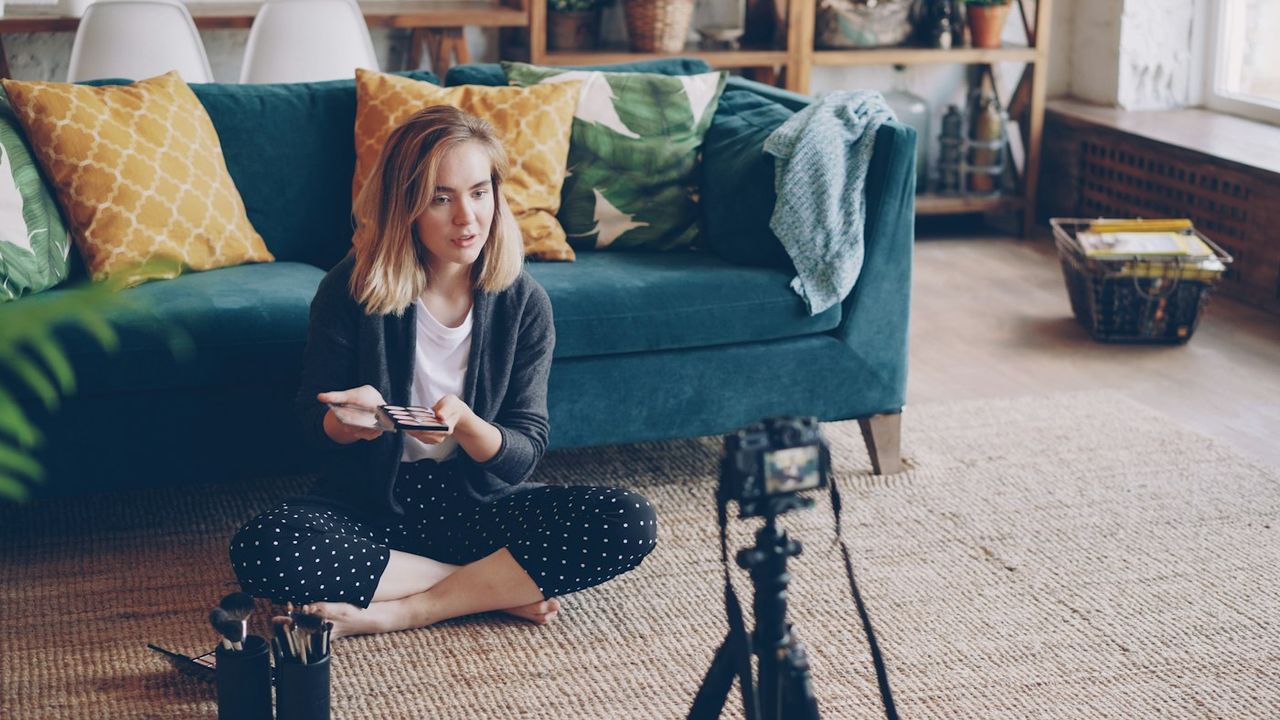 Creator filming a short makeup video with a camera in a living room